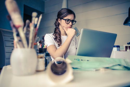 woman thinking in front of laptop