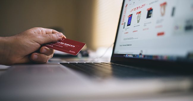 person holding a credit card shopping online
